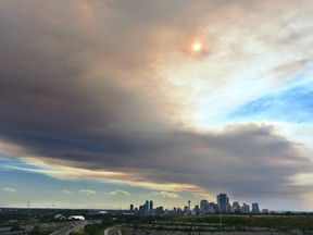 A large plume of smoke darkens Calgary Wednesday evening, blown eastwards from wildfires burning in B.C. and Banff National Park.