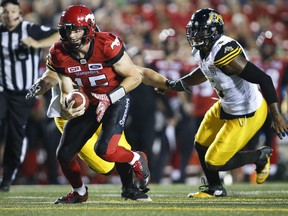 Hamilton Tiger-Cats defensive end Adrian Tracy, right, chases Calgary Stampeders quarterback Andrew Buckley during second half CFL football action in Calgary, Saturday, July 29, 2017.