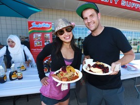 Newlyweds Jen and Michael Dytynyshyn show their variety of breakfast items during the 19th annual Best of the East Stampede Breakfast held on International Avenue in southeast Calgary on Thursday July 13, 2017. The breakfast included  traditional fare of pancakes, ham and some samplings of international food items from around the world breakfast items including East Indian, German, Indonesian, Filipino and new this year, Ethiopia. Jim Wells//Postmedia
Jim Wells, Jim Wells/Postmedia