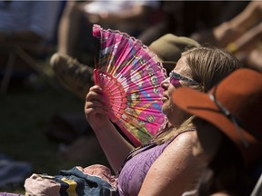 Maryanne Balczer fans herself while watching the band River Whyless on Festival Hall Stage 1 in the afternoon as thousands of fans take in the Calgary Folk Music Festival in Prince's Island Park on Saturday, July 29, 2017 in Calgary, Alta.