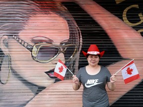 A Calgary vendor shows her Canada Day pride as she poses during 150 celebrations in Chinatown near Riverfront Avenue on July 1, 2017.