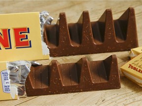 In this photo illustration two bars of the Toblerone Swiss chocolate are shown, at front is the new style 150 gram bar showing the reduction in triangular pieces, in the background is the older style 360 gram bar, pictured in London, Tuesday, Nov. 8, 2016. More valleys, fewer chocolate peaks: The maker of Toblerone Swiss chocolate says it's widened the spaces in its iconic, triangle-array bars for some discount shops in Britain to keep prices down.