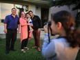 Najat Al Masalmeh, 8, takes photos of her dad Yahya Al Masalmeh, mom Seham Talab and brothers Mohammad and Yousef outside their new home in Falconridge on Wednesday evening July 26, 2017. Mohammad was the first baby born in Calgary to recent Syrian refugee parents.  Gavin Young/Postmedia