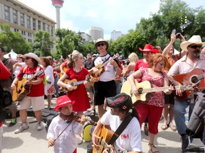 Sacha Jorba-Wu, 4, left, and his father get ready to play with Ian Tyson at Olympic Plaza during Canada's sesquicentennial celebrations in Calgary Saturday July 1, 2017.