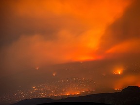 A wildfire burns on a mountain in the distance east of Cache Creek, B.C., in July, 2017