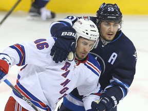 New York Rangers left winger Marek Hrivik (l) is tied up by Winnipeg Jets center Mark Scheifele during NHL hockey in Winnipeg, Man. Thursday December 08, 2016.