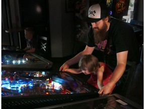 Graham Mackenzie, founder of the Major Minor Music Project and his daughter Vesper, 3, play on a pinball machine at the Atlantic Trap and Gill on Monday, August 28, 2017. The non-profit organization is helping to put on the Silverball Rodeo, a pinball championship and live music event. 
Postmedia Calgary For Silverball Rodeo story by Anna Junker
Kerianne Sproule/Postmedia