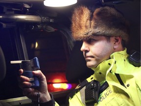 Airdrie, Alta. - Cpl. Darren Turnbull with a breathalyzer in his vehicle as Airdrie RCMP and Calgary Police hold a check stop along Township Road 566 in Balzac on Friday, Dec. 5, 2014.  BRITTON LEDINGHAM / AIRDRIE ECHO / QMI AGENCY
Britton Ledingham