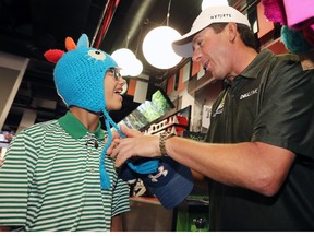 Logan McLean, 13, tries on some goofy hats with PGA golfer Billy Andrade at Sport Chek.