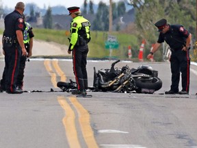 Police investigate the scene of a fatal collision involving a motorcyclist at Lower Springbank Road and 101st Street S.W. on Saturday afternoon August 5, 2017. Gavin Young/Postmedia