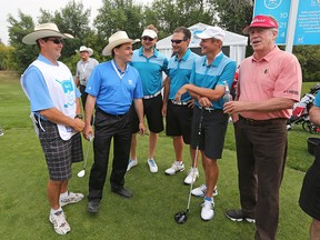 Eddie Melville, far left, listens as his brother Billy gives instructions to players including pro golfer Michael Allen (in pink) at the start of their RBC Pro Am round at the Shaw Charity Classic in Calgary.