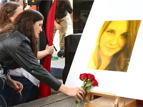 Supporters lay flowers in front of a photo of Heather Heyer during a vigil in downtown Calgary Wednesday, August 16, 2017.