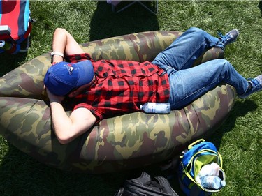 A festival fan rests his eyes while relaxing in the sun during day 2 of Country Thunder Music Festival in Calgary Saturday, August 19, 2017. Jim Wells/Postmedia