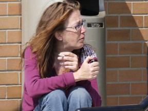 Melinda Harris sits outside a Provincial Courthouse prior to facing charges of Causing Unnecessary Suffering to an Animal, regarding a July 2nd incident of a leashed dog being dragged by a vehicle resulting in its death, in Strathmore, Alta. on Tuesday, Aug. 15, 2017. THE CANADIAN PRESS/Larry MacDougal