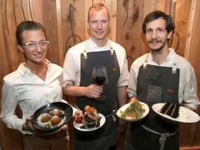 Server Tori Taylor, Head chef Chris Hartman and cook Roberto Ormerod pose with a few menu items at the Fence & Post restaurant in Cochrane.