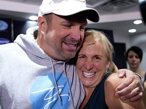 Country singer Garth Brooks hugs Postmedia columnist Valerie Fortney during a press conference at the Scotiabank Saddledome in Calgary on Friday September 1, 2017. Leah Hennel/Postmedia