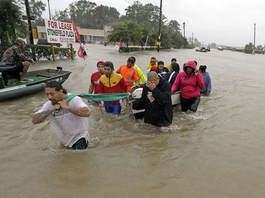 Evacuees wade down Tidwell Road as floodwaters from Tropical Storm Harvey rise Monday, Aug. 28, 2017, in Houston. (AP Photo/David J. Phillip) ORG XMIT: TXDP188