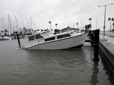 A fishing boat is left partial submerged after Hurricane Harvey swept through the area, Saturday, Aug. 26, 2017, in Corpus Christi, Texas. Harvey has been further downgraded to a Category 1 hurricane as it churns slowly inland from the Texas Gulf Coast, already depositing more than 9 inches of rain in South Texas. (AP Photo/Eric Gay) ORG XMIT: TXEG107