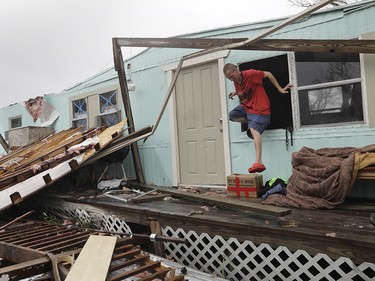 Sam Speights exits a window of his home that was destroyed in the wake of Hurricane Harvey, Monday, Aug. 28, 2017, in Rockport, Texas. (AP Photo/Eric Gay) ORG XMIT: TXEG118