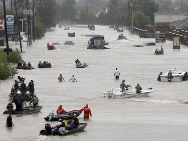 People and rescue boats line a street at the east Sam Houston Tollway as rescues continue from flooding following Tropical Storm Harvey. (Melissa Phillip/Houston Chronicle via AP) ORG XMIT: TXHOU104