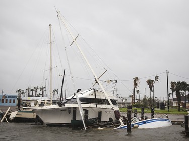 A boat sits capsized in the Rockport marina after Hurricane Harvey ripped through Rockport, Texas, on Saturday, Aug. 26, 2017.  The fiercest hurricane to hit the U.S. in more than a decade spun across hundreds of miles of coastline where communities had prepared for life-threatening storm surges, walls of water rushing inland.  (Nick Wanger/Austin American-Statesman via AP) ORG XMIT: TXAUS109