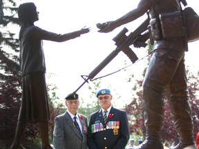 James Blake, of Calgary (L) and Gary Littlewood, of Coleman, AB pose as they look at a statue during Peacekeeper's Day in Calgary Sunday, August 13, 2017. The two former soldiers have well over 50 years military service between them all over Europe and the Middle East. Jim Wells/Postmedia