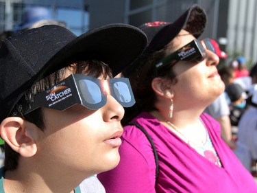 Mustafa Imran and his mom Eesha wear protective glasses as they watch the great North American solar eclipse from Telus Spark on Monday, Aug. 21, 2017.