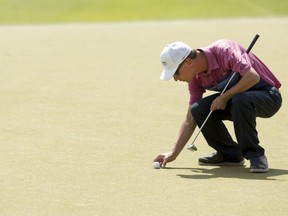 Calgary's Kyle Miller places his ball for a putt on the green of hole 18 during Round 2 of the ATB Financial Classic, part of the Mackenzie Tour-PGA Tour Canada, at Country Hills Golf Club on Friday, August 11, 2017 in Calgary, Alta. Britton Ledingham/Postmedia Network