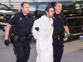 Calgary police escort Daniel Paul Loveys, 28, into the CPS arrest processing unit on Thursday, Aug. 10 2017. Bryan Passifiume/Postmedia Network