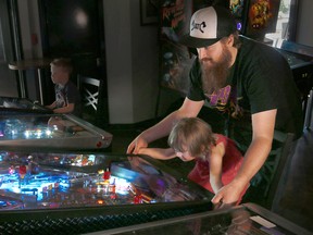 Graham Mackenzie, founder of the Major Minor Music Project and his daughter Vesper, 3, play pinball at the Atlantic Trap and Gill on Monday, Aug. 28, 2017. The non-profit organization is helping to put on the Silverball Rodeo, a pinball championship and live music event.