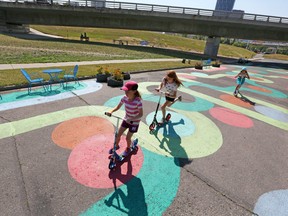 Joy McCullagh, 10, Reilly McMillan, 12, and Gracie, McMillan, 9, ride down a painted section of McDougall Road N.E. next to the fourth avenue flyover on Wednesday August 9, 2017.