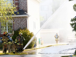 Calgary Fire battle a house fire in the Community of Scenic Acres which spread to a second home on Scurfield Dr. N.W. on Sunday August 27, 2017. Darren Makowichuk/Postmedia