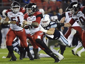 Calgary Stampeders quarterback Bo Levi Mitchell is chased by Toronto Argonauts defensive lineman Jeffrey Finley during second half CFL football action in Toronto on Thursday, Aug. 3, 2017.