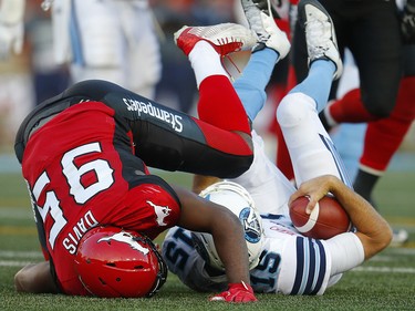 Toronto Argonauts quarterback Ricky Ray is sacked by Ja'Gared Davis of the Calgary Stampeders during CFL football on Saturday, August 26, 2017. Al Charest/Postmedia