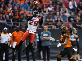 Calgary Stampeders' Jamar Wall, left, nearly intercepts a pass intended for B.C. Lions' Emmanuel Arceneaux during the first half of a CFL football game in Vancouver, B.C., on Friday August 18, 2017. Darryl Dyck/The Canadian Press