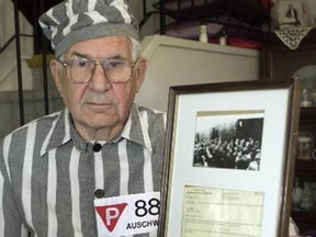 Calgary-08/24/01-Sigmund Sobolewski looks back on his time at Auschwitz as he is informed of a $15,000 cheque he will be given as compensation for the work he did while in the concentration camp. He is pictured here in a replica uniform holding a letter the camp sent to his mother along with his clothes, leaving her to believe that he was dead. Photo by Jenelle Schneider/Calgary Herald (