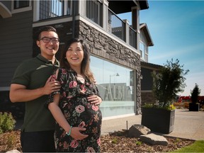 Paul Lee and Sarah Yoo, who are expecting in August, stand outside their new home in the community of the Rise at West Grove Estates.