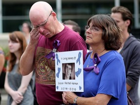 Don Harman and his wife, Laura Marshall, hold a photo of their son Graham Marshall-Harman who died of a fentanyl overdose in 2016, during a ceremony at City Hall on International Overdose Awareness Day in Calgary on Thursday.