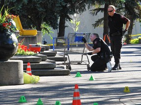 Police investigate the crime scene at Olympic Plaza, where Robyn Gladue was stabbed and beaten to death on July 26, 2013.