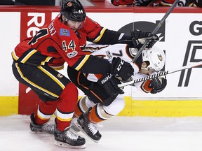 Anaheim Ducks' Andrew Cogliano, right, is hit by Calgary Flames' Matt Bartkowski during second period NHL playoff action in Calgary, Alta., Monday, April 17, 2017. THE CANADIAN PRESS/Larry MacDougal ORG XMIT: LMD108