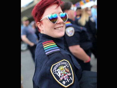 Courtney Tario with Calgary's 911dispatchers shows the department's rainbow shoulder patch during the Calgary Pride Parade on Sunday September 3, 2017.