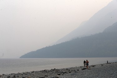 People walk along smoke shrouded Waterton Lake on Wednesday September 6, 2017. The town is currently under a voluntary evacuation order that could be changed to a mandatory order with 1 hours notice. A large wildfire is on the edge of Waterton National Park and threatens the town.
Gavin Young/Postmedia