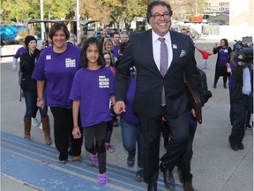 Naheed Nenshi holds his niece Sofia's hand as he walks into Calgary City Hall with supporters to file nomination papers in his bid to be re-elected mayor of Calgary.