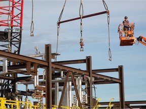 Steel workers hook cables from giant 300-tonne cranes to an 80-tonne module at the Cenovus Energy Christina Lake SAGD oilsands facility near Conklin, Alta., 120 kilometres south of Fort McMurray, Alta. on August 28, 2013.