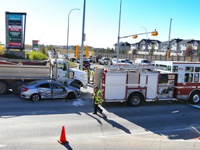 Emergency crews contain the scene after a car was crushed between a dump truck and a Calgary fire engine in Country Hills.