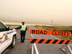 An RCMP officer with the Pincher Creek detachment looks at a map at a road block on Highway 6 south at Secondary 505, south of Pincher Creek, AB on Tuesday, September 12, 2017.