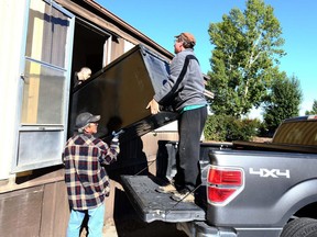 Kelly (didn't want his last name used) (L) gets help from his brothers as they move a fridge out of a narrow door at the Midfield Trailer Park in northeast Calgary Saturday, September 23, 2017. Kelly has lived in the park at #6  for the past five years and was moving large items out of the trailer as the end-of-the-month deadline looms for residents. Jim Wells/Postmedia