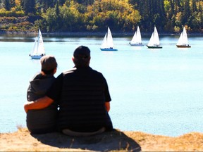 Donna Duong and David Linton pause and take in sailboats on the Glenmore Resevoir in southwest Calgary Sunday, September 24, 2017. Temperatures are expected to be above normal for the last week of September. Jim Wells/Postmedia