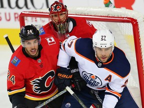 Calgary Flames Travis Hamonic battles against Milan Lucic of the Edmonton Oilers in front of goaltender Mike Smith during NHL pre-season hockey at the Scotiabank Saddledome in Calgary on Monday, September 18, 2017. Al Charest/Postmedia