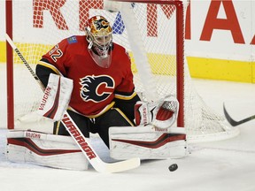 Calgary Flames goalie Jon Gillies, left, stops a shot by Vancouver Canucks' Darren Archibald during first period NHL pre-season action in Calgary, Alta., Wednesdy, Sept. 20, 2017.